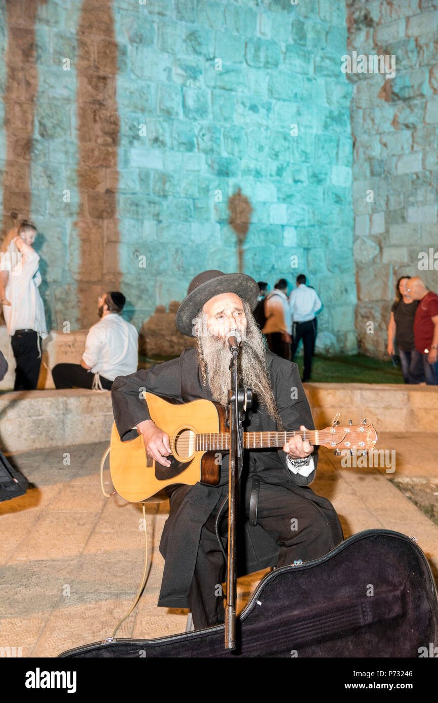 Jerusalén, Israel. 3 Jul, 2018. Un ultra ortodoxos ('Haredi") hombre  tocando una guitarra cerca de las murallas de la ciudad vieja de Jerusalén  durante el 2018 Festival de las luces. Este es