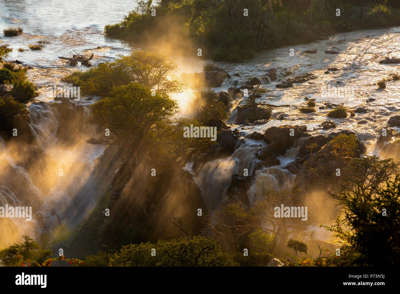 Epupa Falls en el río Kunene, en el norte de Namibia y sur de Angola frontera. Amanecer la luz solar en el agua nebulizada. Foto de stock