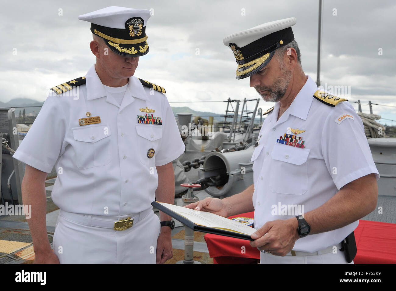 PEARL HARBOR (26 de mayo de 2015) Royal Canadian Navy Contralmirante. William Truelove, comandante de las fuerzas marítimas del Pacífico (MARPAC), se prepara a presentar Cmdr. Todd E. Hutchison, comandante de los misiles guiados destructor USS Michael Murphy (DDG 112), con la unidad de las Fuerzas Canadienses elogio abordo de Michael Murphy en base común Harbor-Hickam Perla. Truelove presentó también Contralmirante. Rick Williams, comandante de la región marina de Hawai y el Grupo de superficie Naval del Pacífico Central, con la unidad de las Fuerzas Canadienses de elogio. El elogio fue dado en reconocimiento por los esfuerzos de recuperación de Su Majes Foto de stock