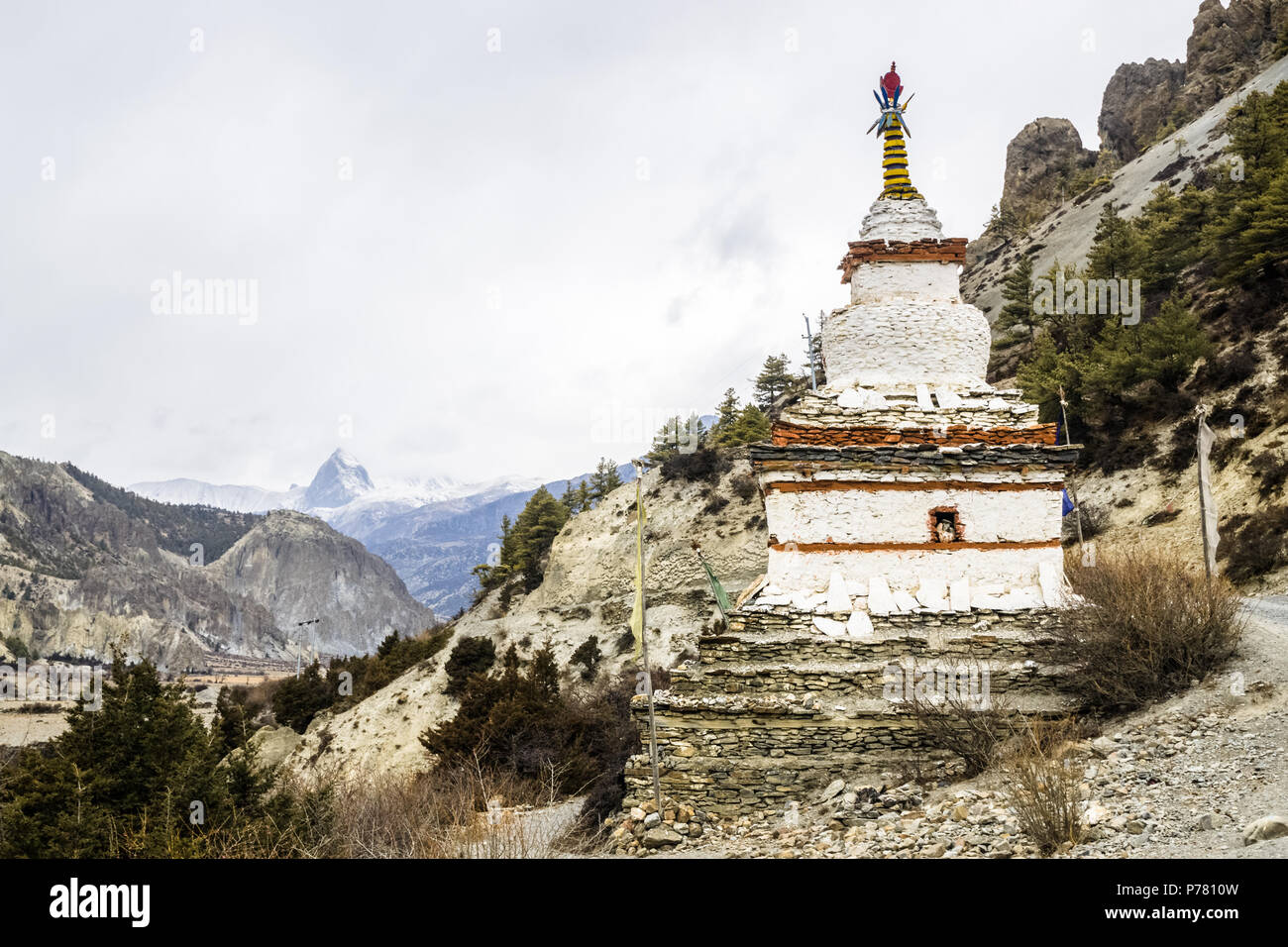 Budista Stupa blanco y nevados picos de montaña cerca de Braga en el sendero del circuito de Annapurna, Nepal Foto de stock