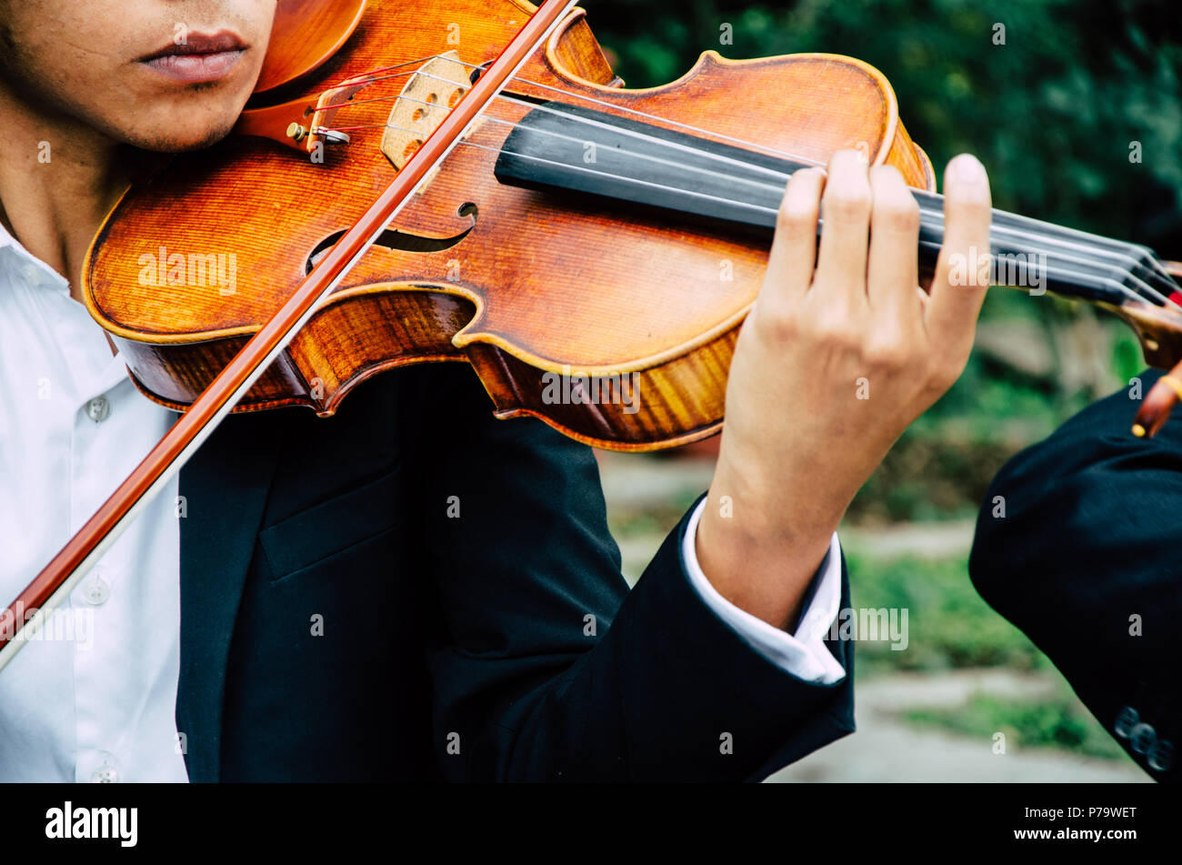 El arte y el artista. Hombre elegante joven violinista a tocar el violín en negro. Música clásica. chico instrumento musical. Foto de stock
