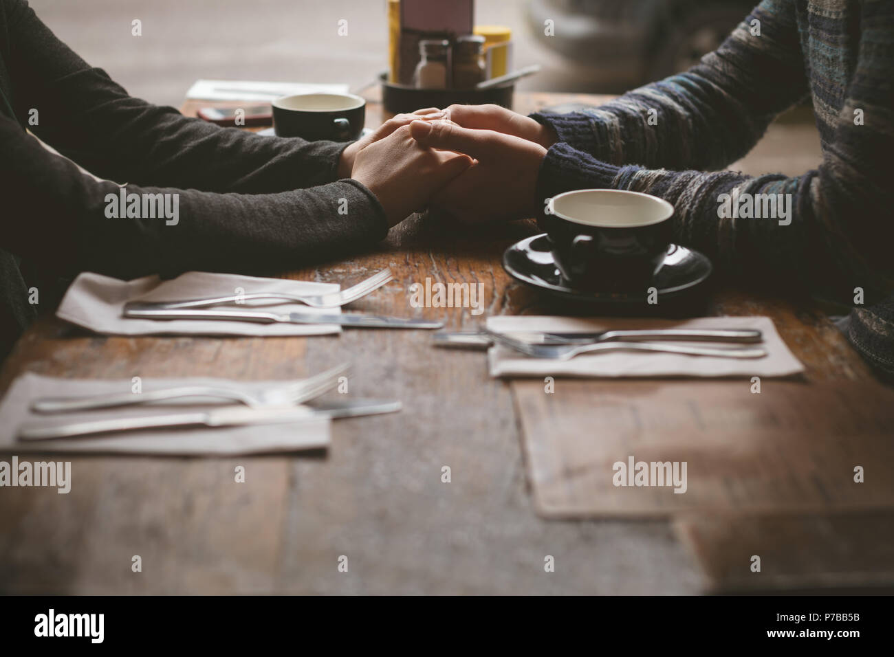 Las manos de la pareja en la cafetería Foto de stock