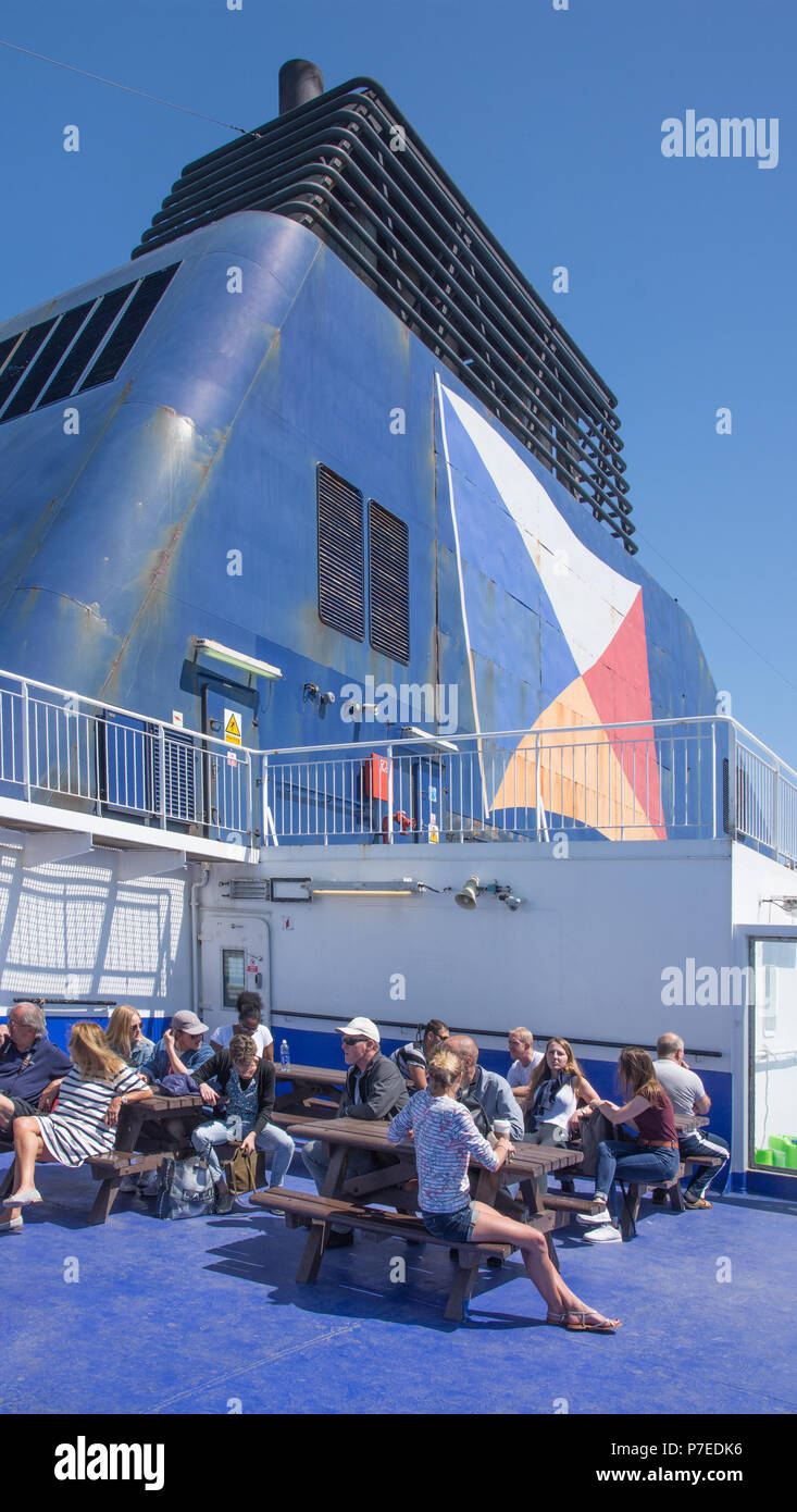 Las personas tomando sol en la cubierta trasera abierta de P&O Ferry dejando Dover con embudo en antecedentes. Foto de stock