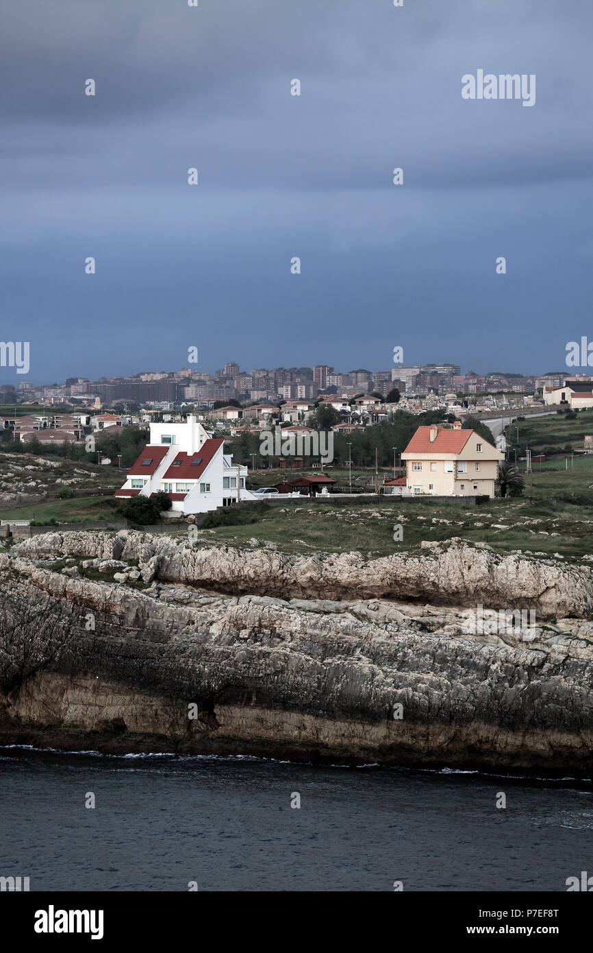 Casas cerca de acantilados rocosos con vistas al océano Atlántico cerca de Gijón, Asturias, España Foto de stock