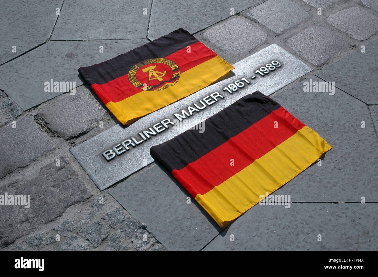 Bandera de Alemania y la RDA junto a la marca de la evolución histórica del Muro de Berlín, la Bernauer Straße, Prenzlauer Berg/Bodas Foto de stock