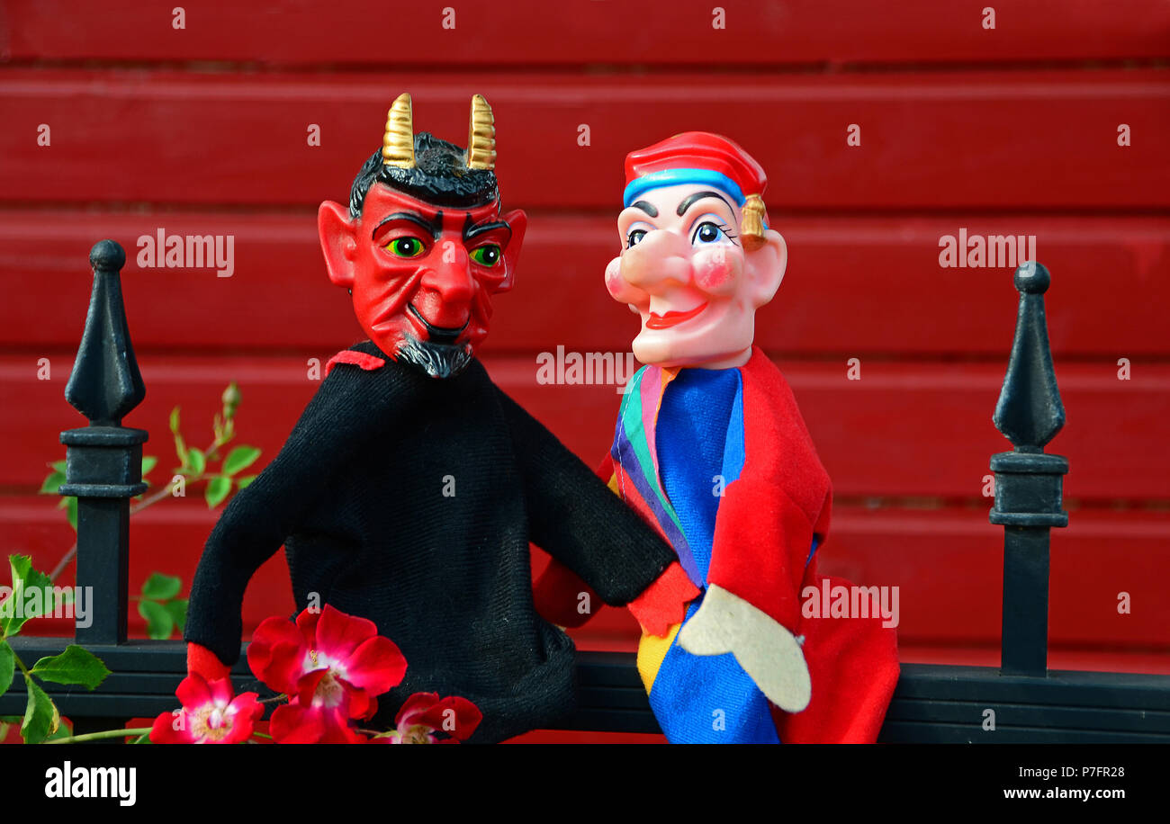 Punzón de marionetas, Punch y diablo sentado en una herradura de metal Foto de stock