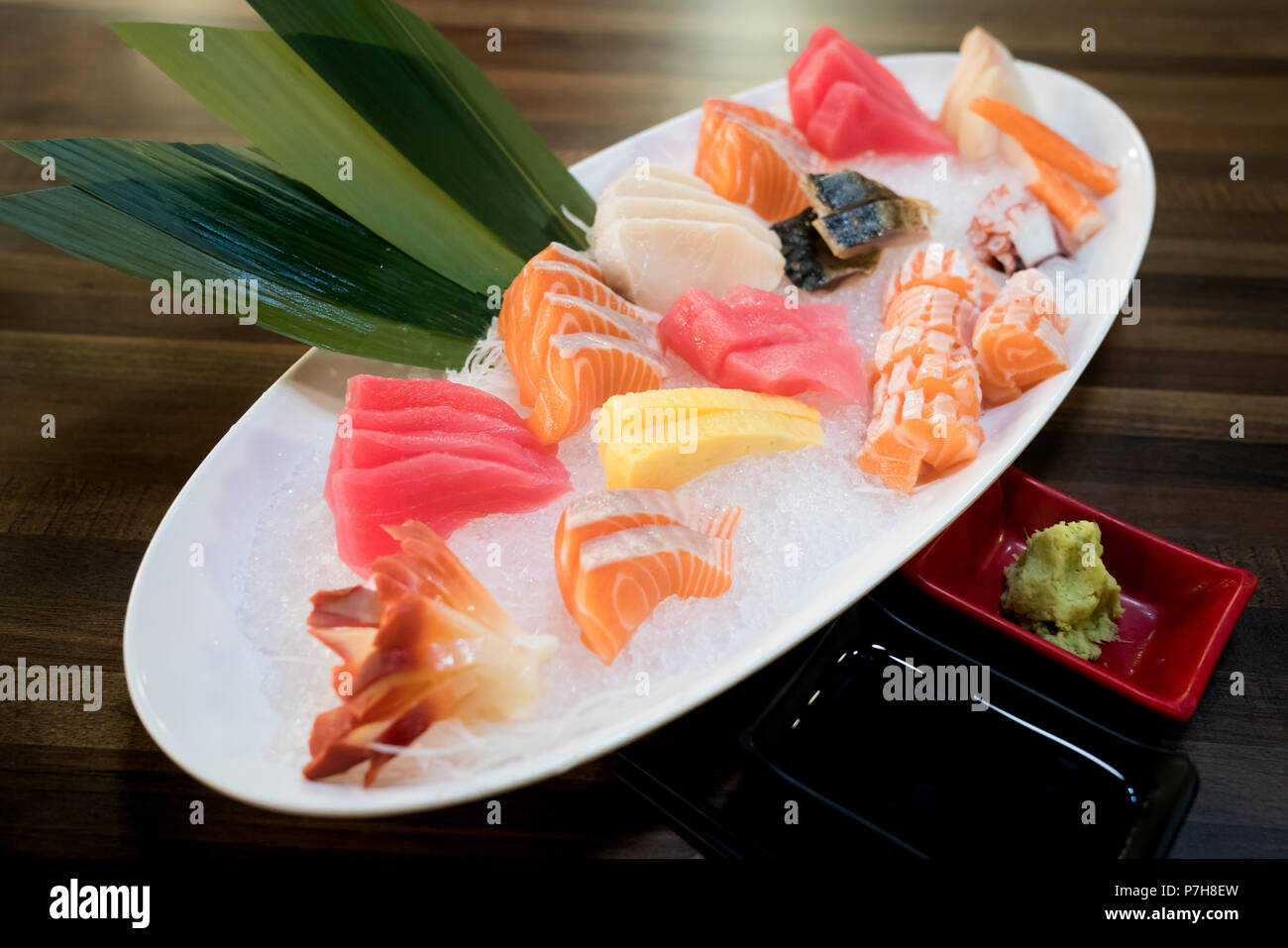 Rodajas de pescado sashimi mixto en hielo en el recipiente blanco. Sashimi  de atún salmón Hamachi Gamba y navegar en calma, pescado crudo, en comida  japonesa restaurante asiático Fotografía de stock -