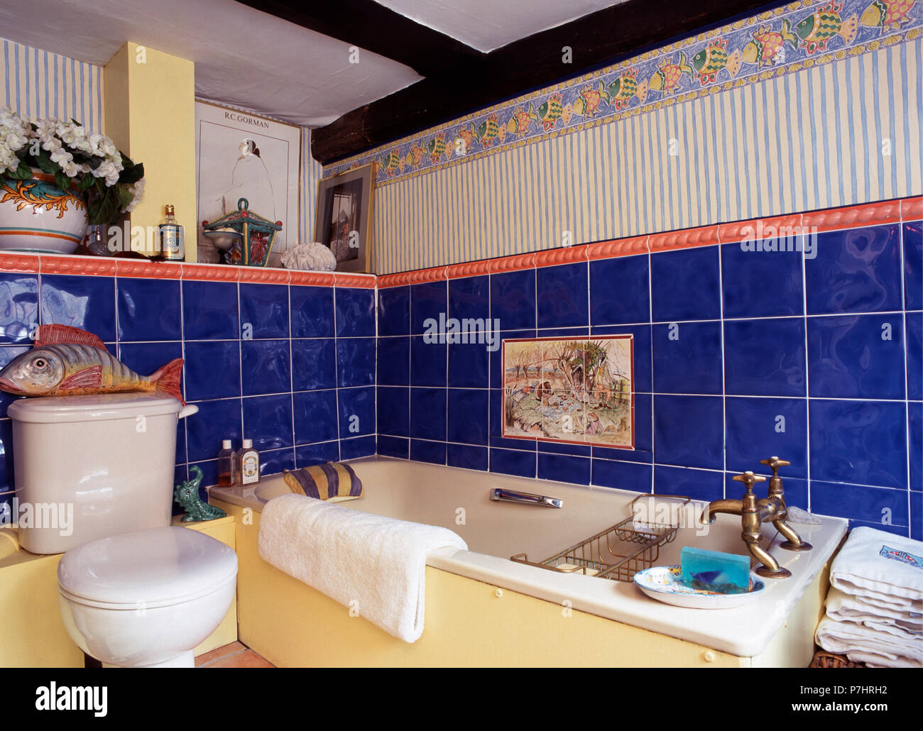 Papel tapiz y azulejos de cerámica de color azul brillante en la pared  sobre la bañera en el cuarto de baño pequeño 80 Fotografía de stock - Alamy
