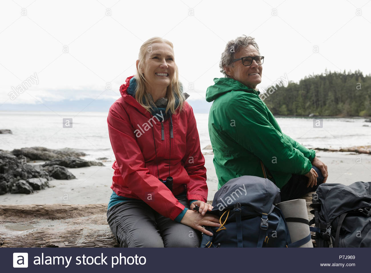 Despreocupada pareja senior activo de mochilero, descansando en la playa resistente Foto de stock