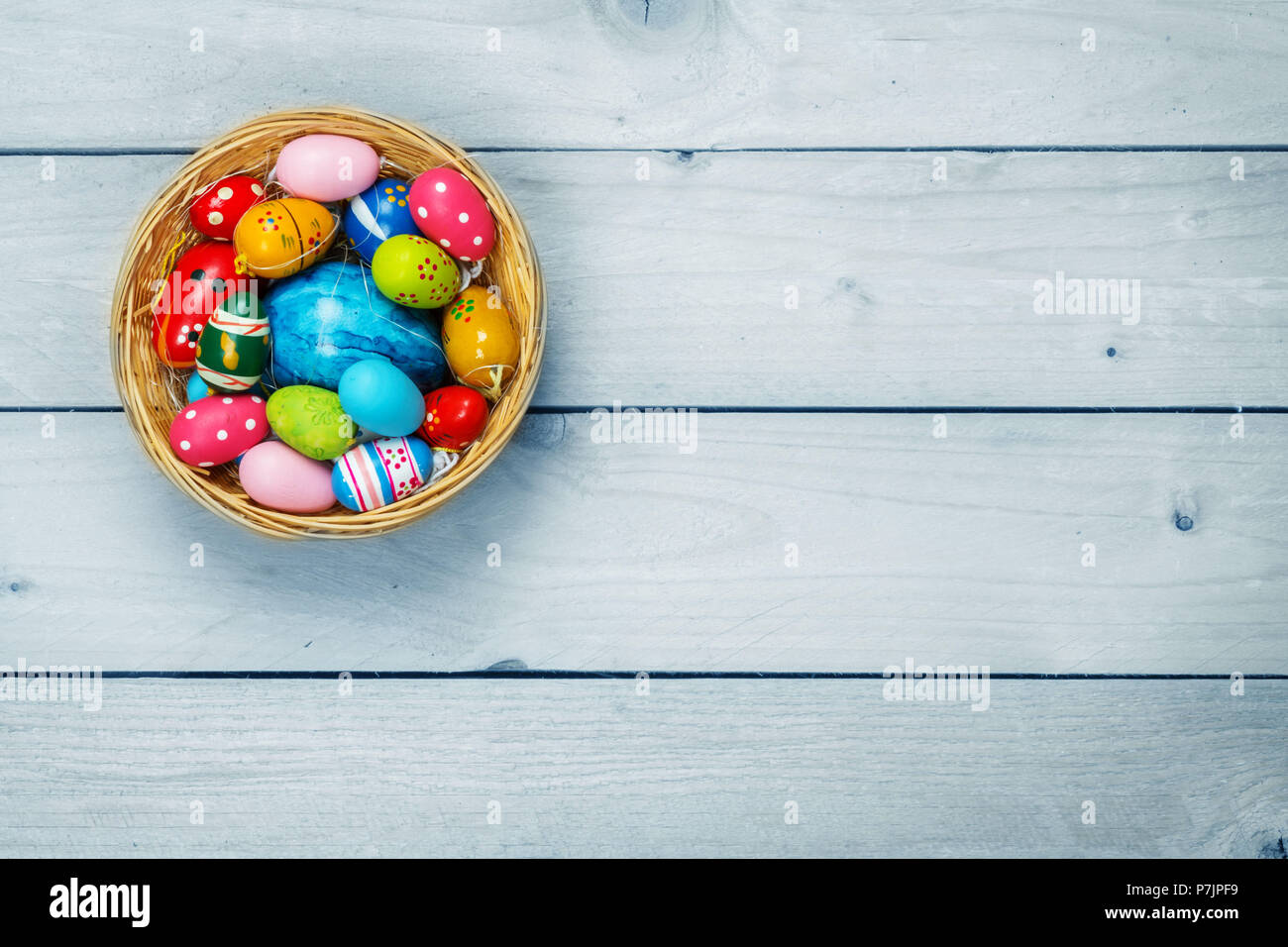 La Pascua, los bodegones, los huevos de Pascua en la cesta en madera Foto de stock