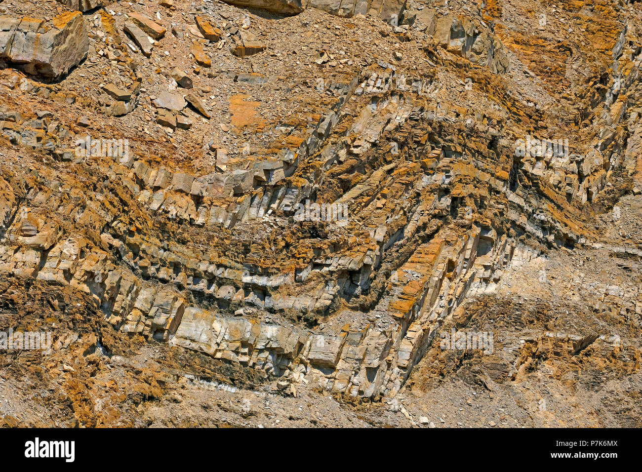 Ondulado desplegada, antiguas y coloridas capas de depósitos fluviales en intemperie y deslizó fuera de roca de deslizamiento en seco de un río en Damaraland, Namibia Foto de stock