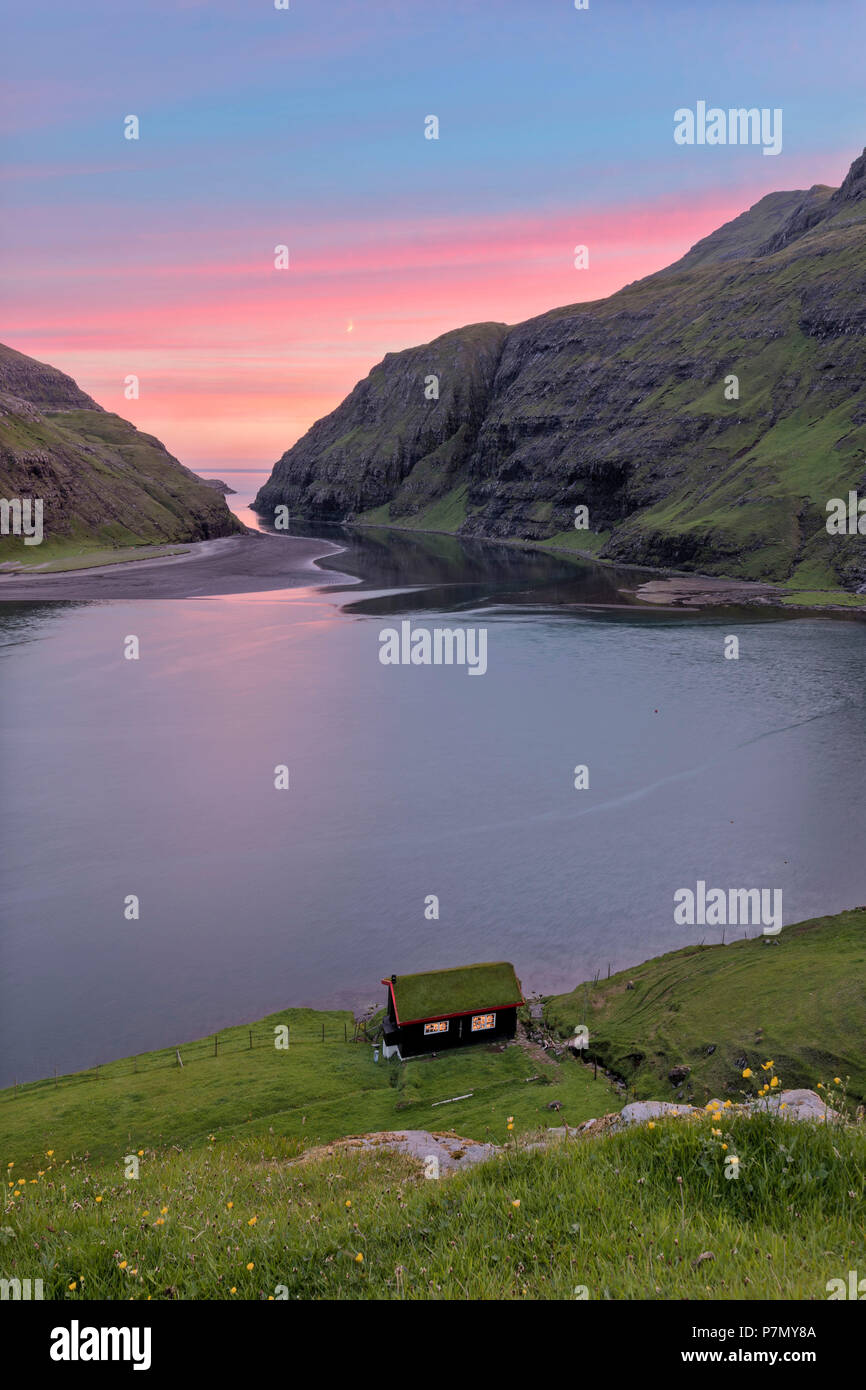 Casa aislada en la orilla de la laguna de agua de mar, la isla de Streymoy Saksun, Islas Feroe Foto de stock