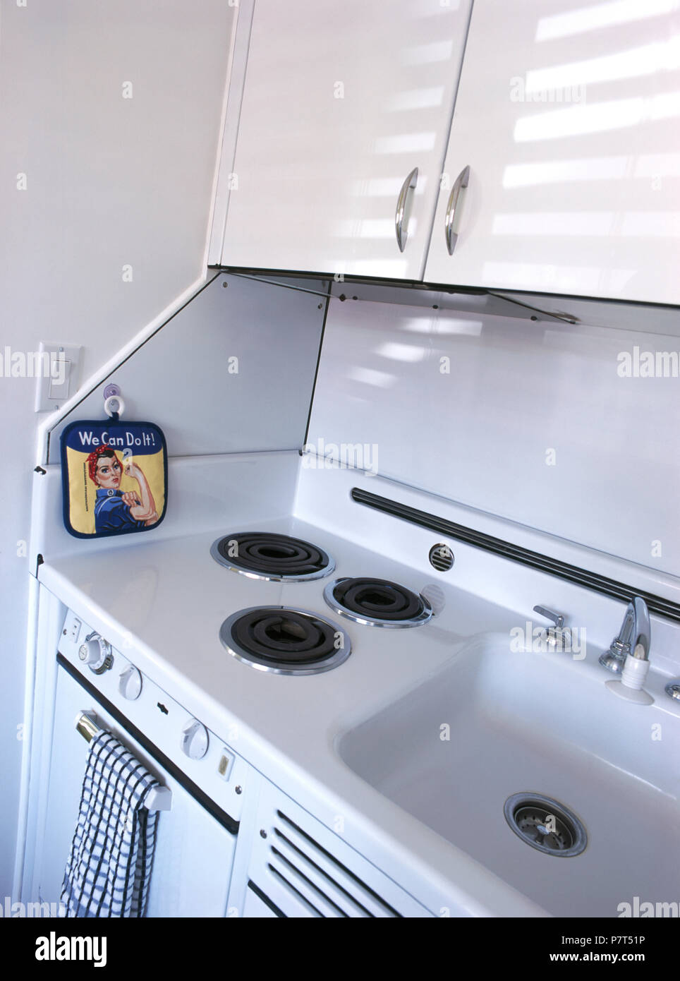 Hundirse junto a aros eléctricos fijados en la encimera sobre horno en  cocina pequeña Fotografía de stock - Alamy