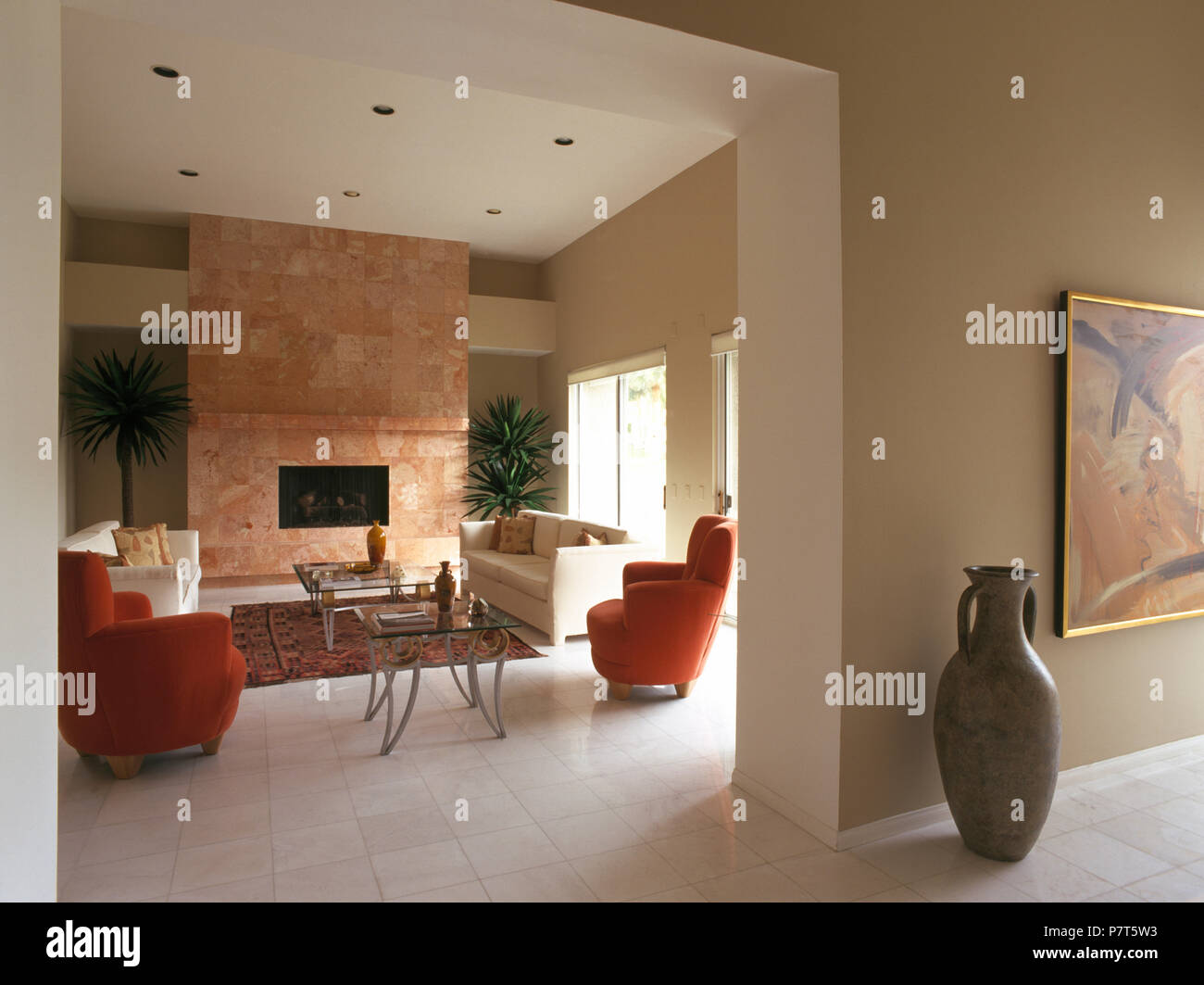 Tall en salón diáfano con vista de la moderna sala de estar con sillones rojos y piso de baldosas blancas Fotografía de stock - Alamy