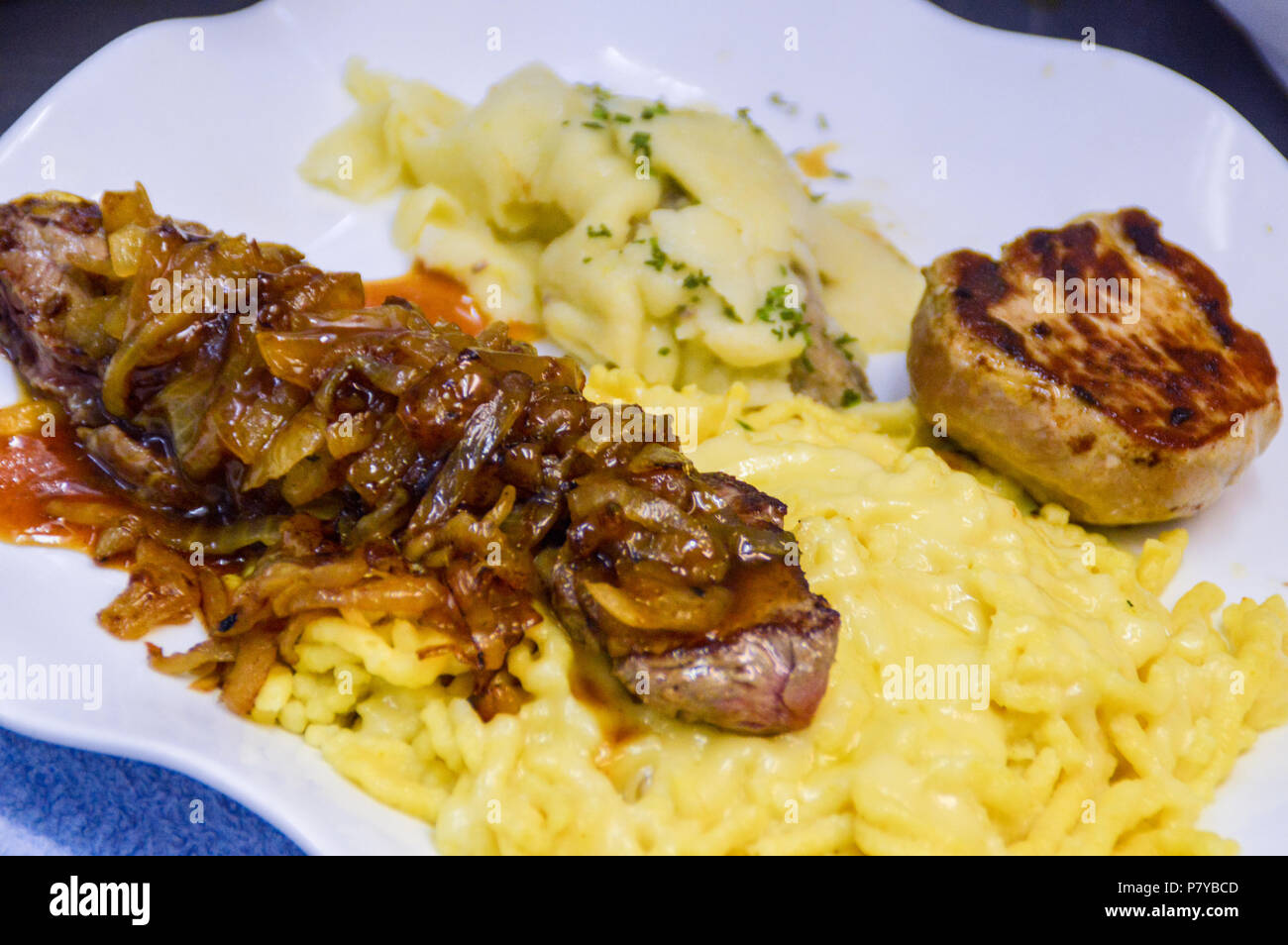 Comida alemana. Spätzle, bistec de ternera y medallón de cerdo con chucrut. Foto de stock