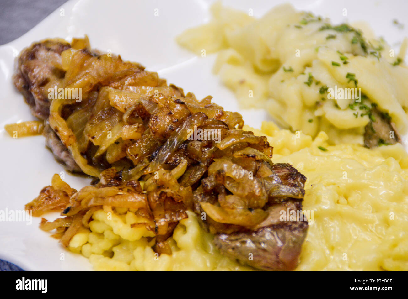 Comida alemana. Spätzle, bistec de ternera y medallón de cerdo con chucrut. Foto de stock