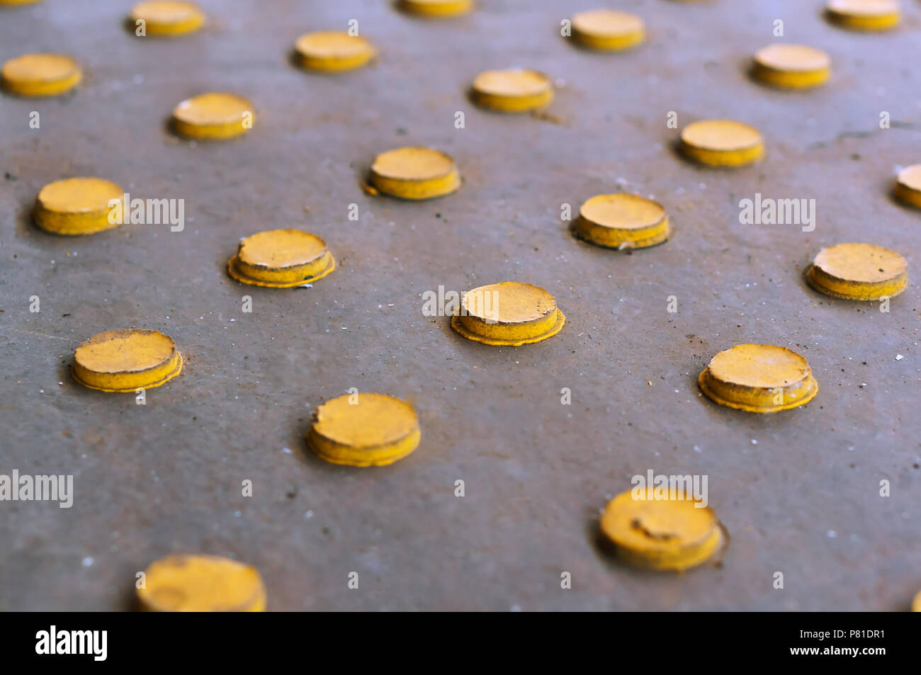 Botones amarillos sobre un fondo gris, círculos amarillos dispuestas en filas. Foto de stock