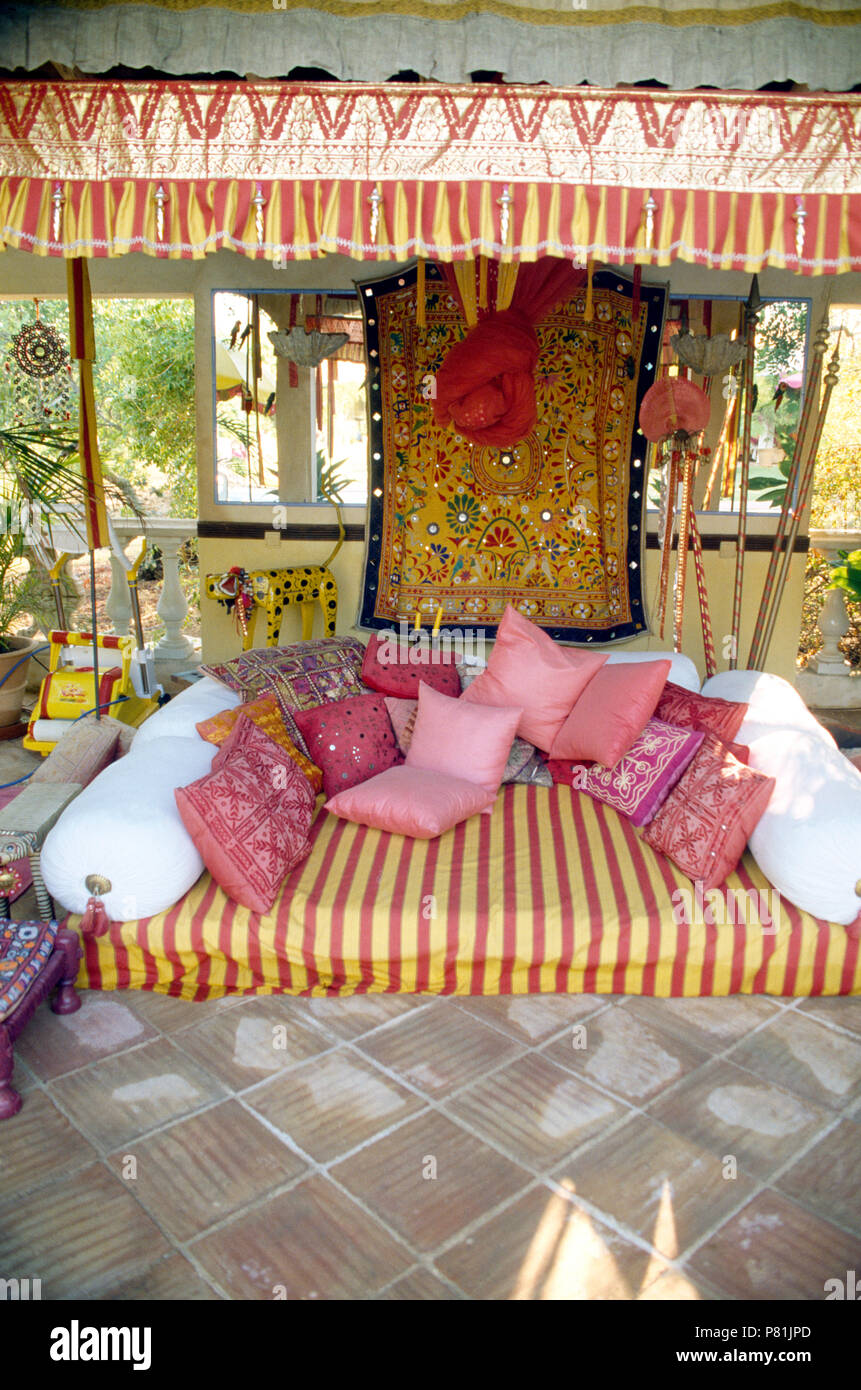 Cojines de color rosa y blanco refuerza el sofá de estilo Indio con flecos  en el balcón techado de villa portuguesa Fotografía de stock - Alamy