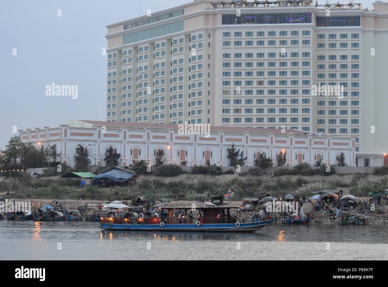 Contraste de hoteles de lujo y barcos de pesca y la pobreza de las minorías musulmanas a lo largo del río Mekong en Phnom Penh, Camboya Foto de stock