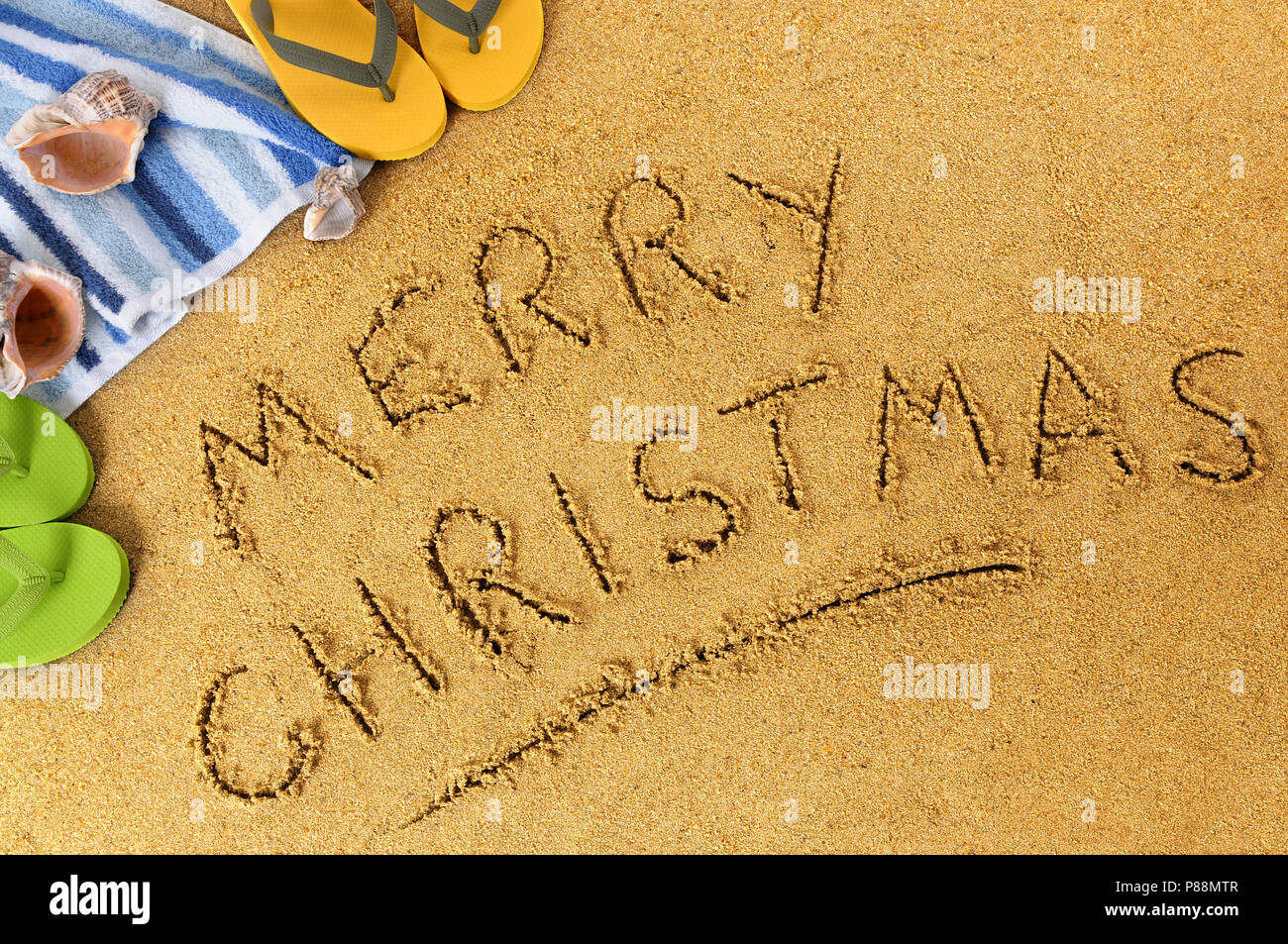 Feliz Navidad mensaje escrito en la arena en una playa soleada, Navidad vacaciones de playa concepto Foto de stock