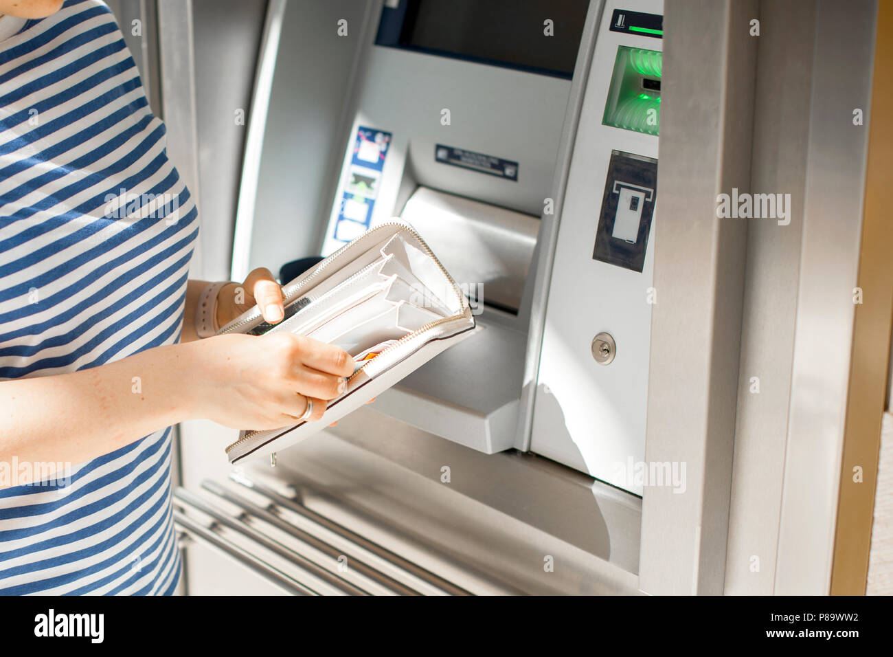 Una mujer usa una tarjeta de crédito en un cajero automático en la calle.  Operación con dinero. El pago. Espacio de copia Fotografía de stock - Alamy