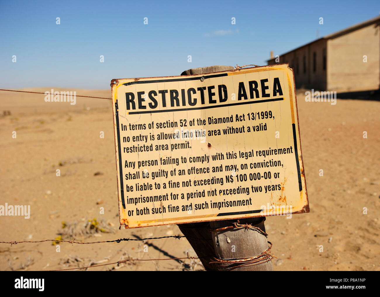 La entrada a los campos de diamantes prohibido el escudo de pie en la arena junto a la antigua ciudad de diamante, la ciudad fantasma de Kolmanskop, Foto de stock