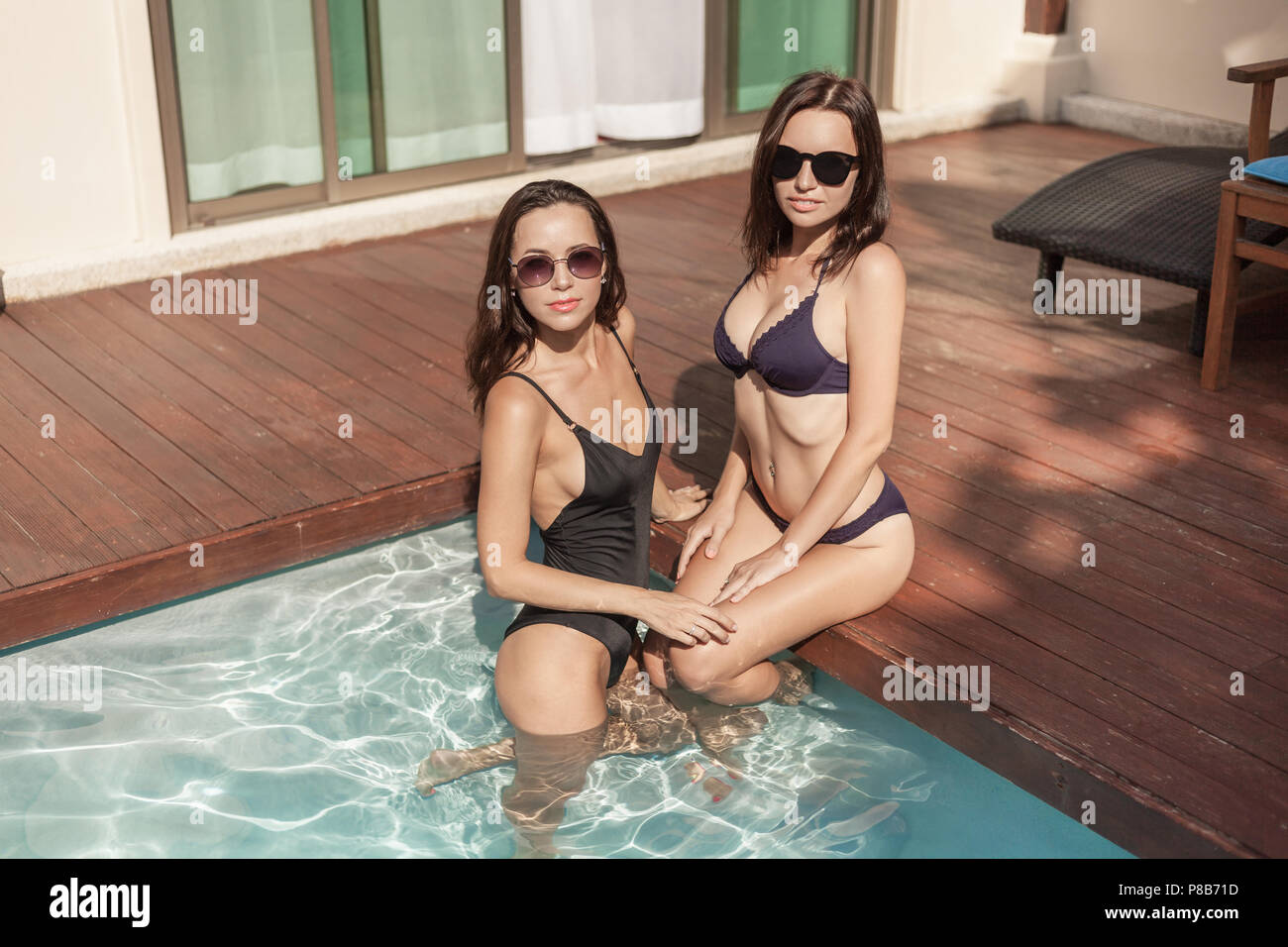 Las mujeres jóvenes y atractivas en bikini y traje de baño en la piscina del hotel Foto de stock
