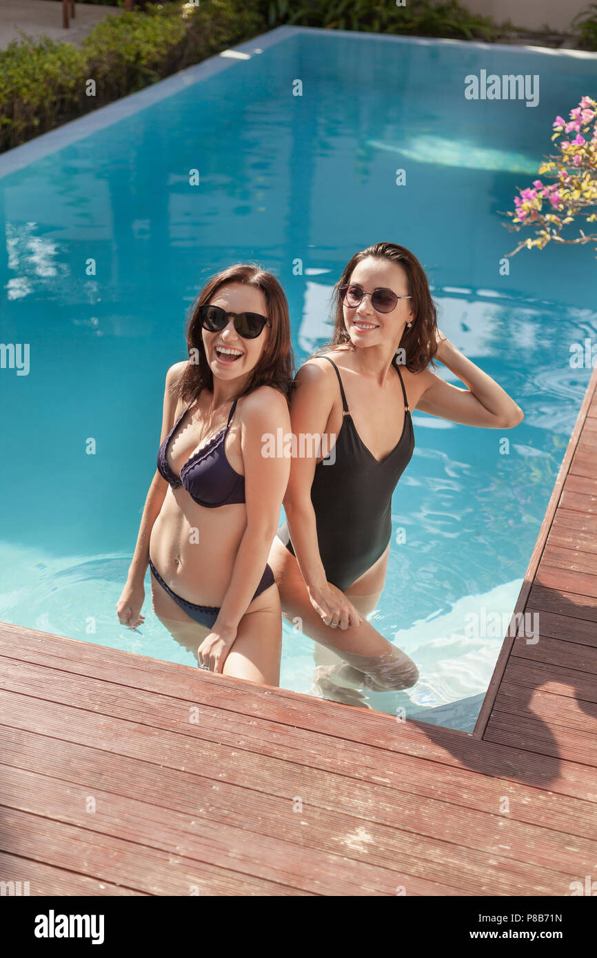Feliz mujeres jóvenes en bikini y bañador de pie en la piscina Fotografía  de stock - Alamy