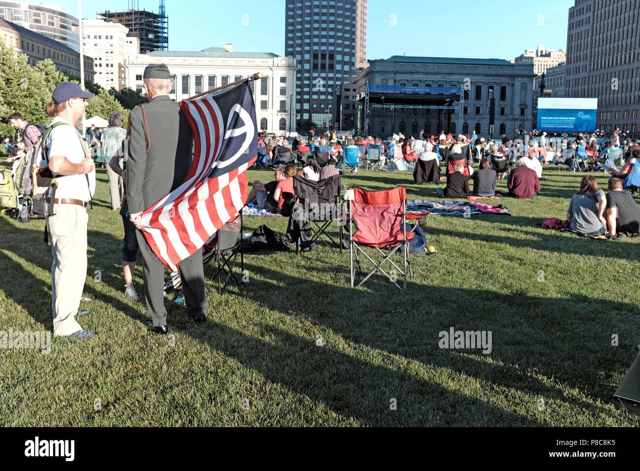 El veterano tiene una bandera estadounidense por la paz en el Mall B en Cleveland, Ohio, EE.UU. Orquesta de Cleveland durante la anual celebración del Día de la independencia en julio de 2018 Foto de stock