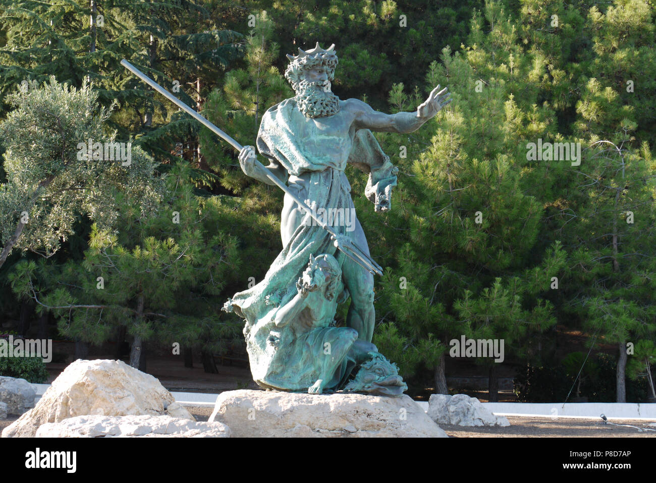 Escultura de Neptuno con una lanza en una piedra en el fondo de un