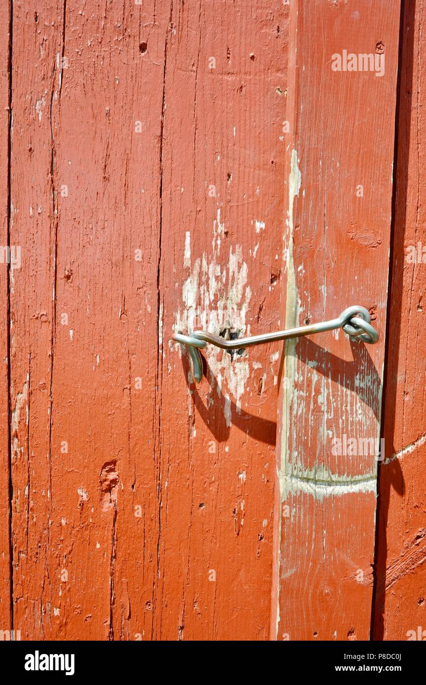 Cerca de un antiguo ojo un gancho en la parte exterior de un granero rojo  galpón para mantenerlo cerrado y bloqueado/asegurado en una antigua granja  en Wisconsin, EEUU Fotografía de stock -
