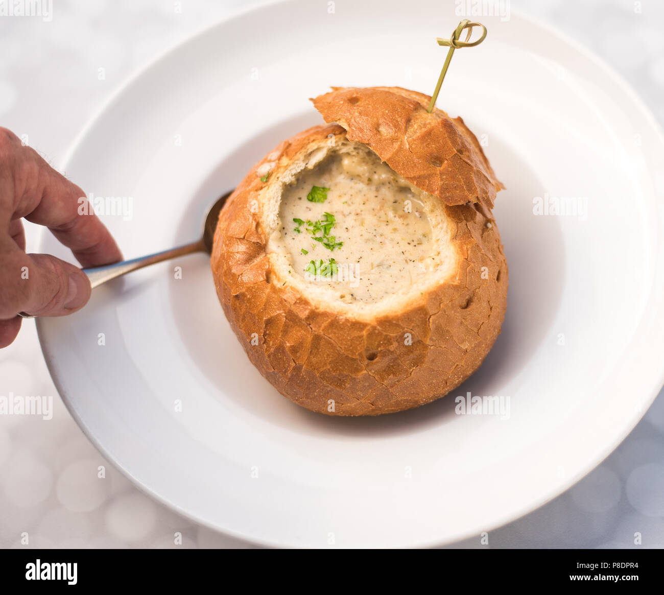 Deliciosa sopa cremosa en un cuenco de pan agrio Foto de stock