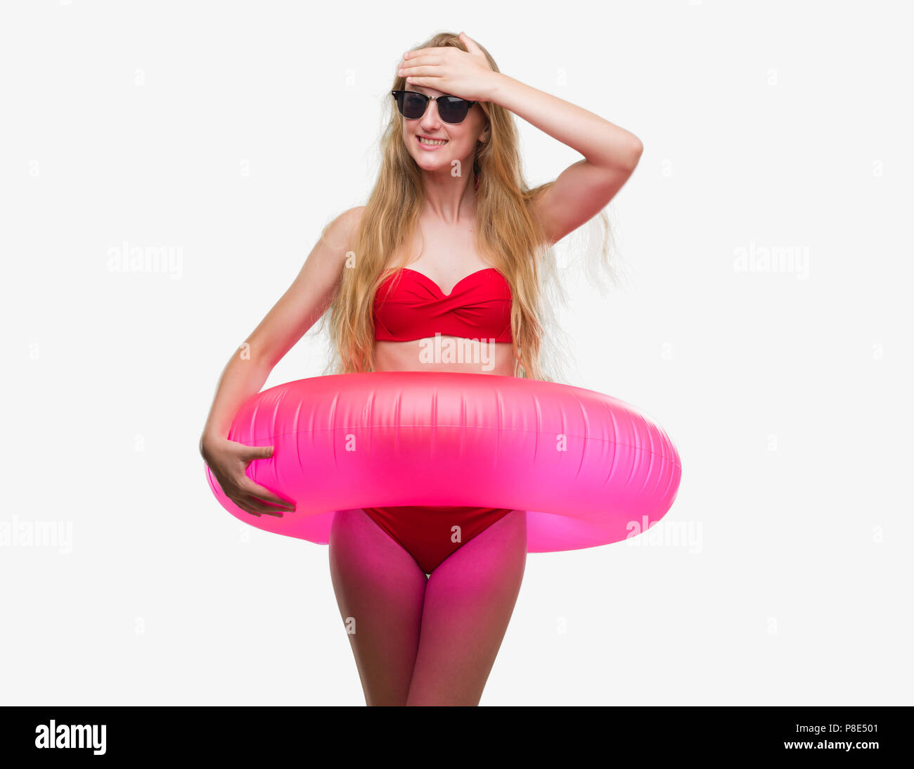 Adolescente rubia mujer vistiendo bikini rosado y la celebración de un  flotador destacó con las manos en la cabeza, conmocionado con vergüenza y  cara de sorpresa, frustrado y enojado Fotografía de stock -