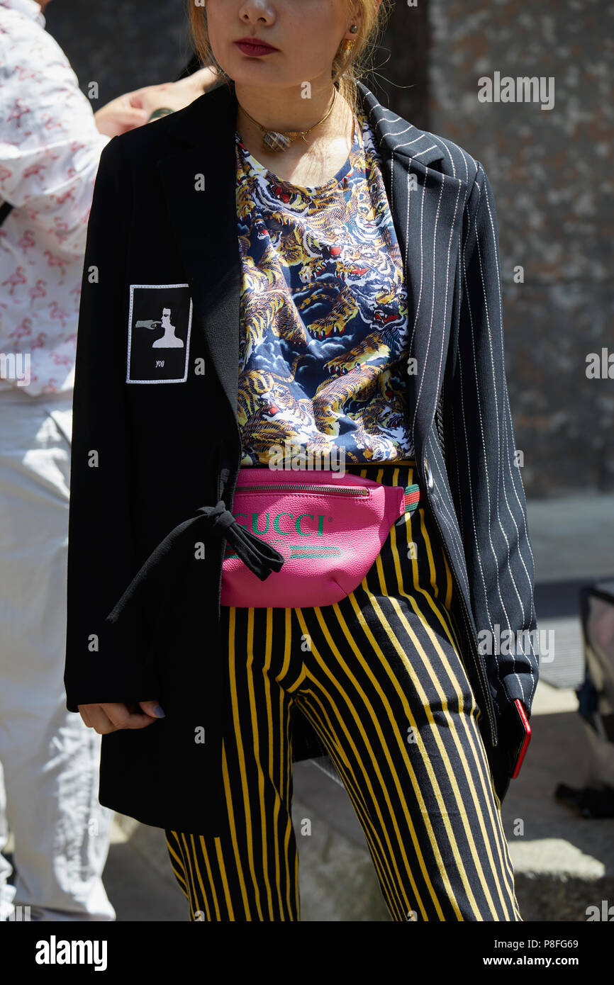 Milán - 16 DE JUNIO: Mujer con rosa Funda de Gucci y pantalones a rayas  negro y amarillo antes de Marni Fashion Show, la Semana de la moda de Milán  street style