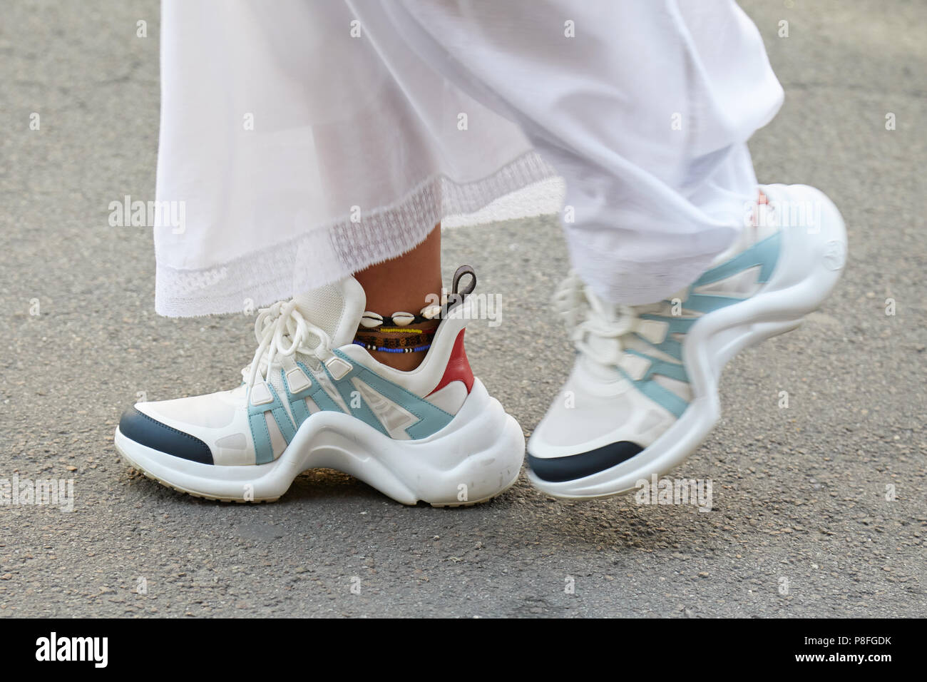 Milán - 16 DE JUNIO: Mujer con blanco y azul Louis Vuitton zapatillas  caminando antes de Marni