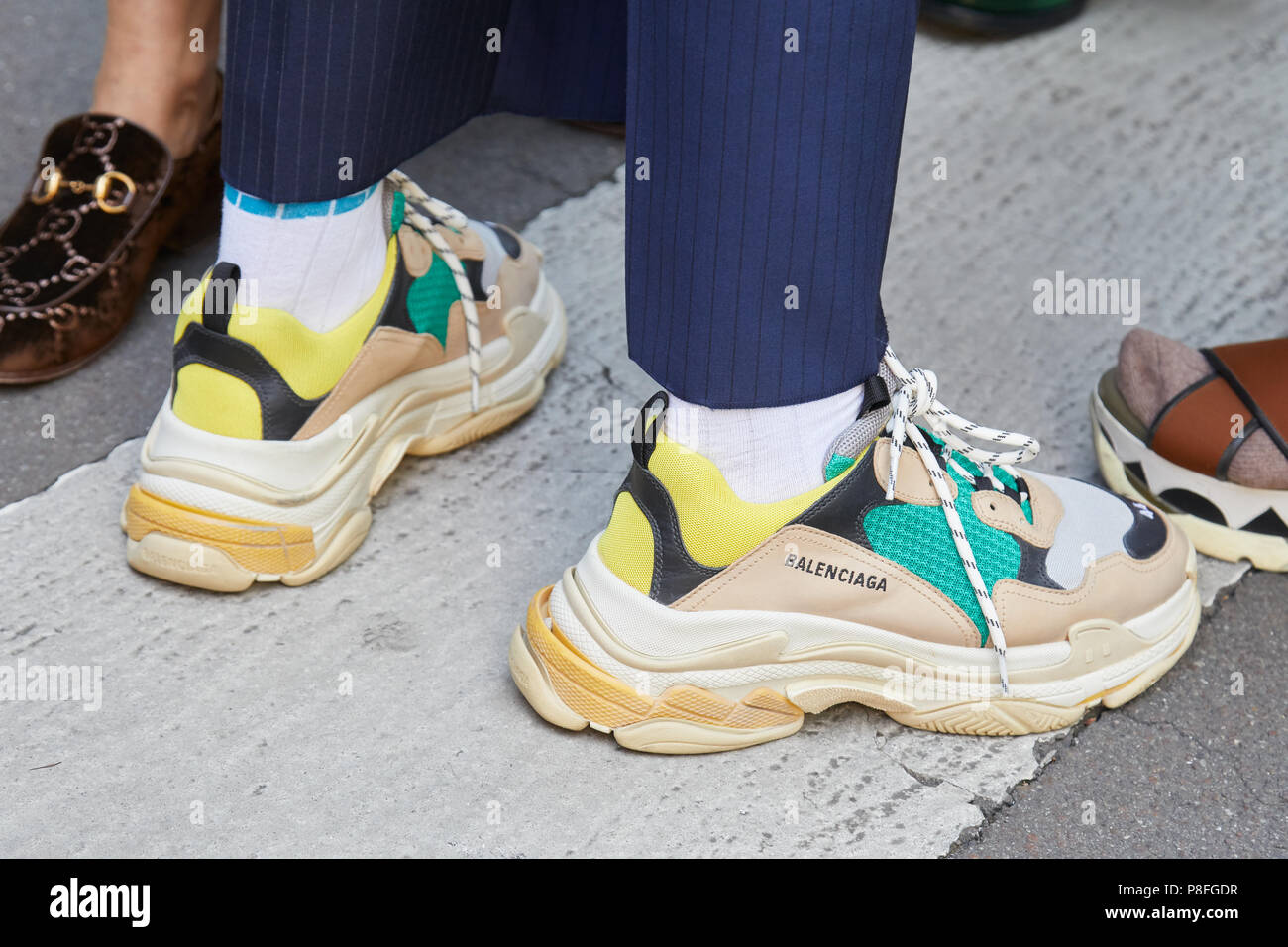 Milán - 16 de junio: el hombre con zapatos de Balenciaga en beige, amarillo  y verde, colores antes de Marni Fashion Show, la Semana de la moda de Milán  street style el