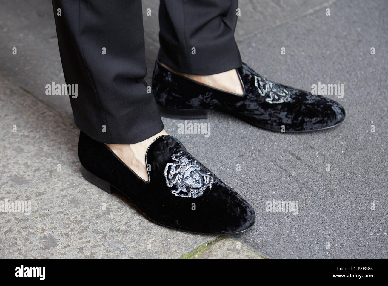 Milán - 16 de junio: el hombre con zapatos de Versace de terciopelo negro con cabeza de antes de Versace Fashion Show, la Semana de la de Milán street style