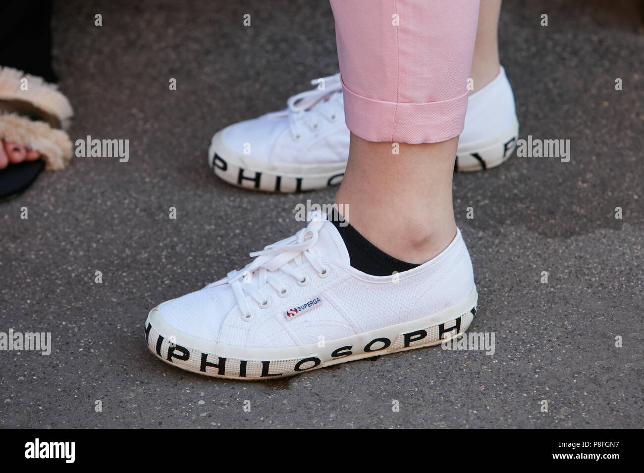 Milán - 17 DE JUNIO: Mujer con blanco Superga Filosofía zapatos antes de  Prada Fashion Show, la