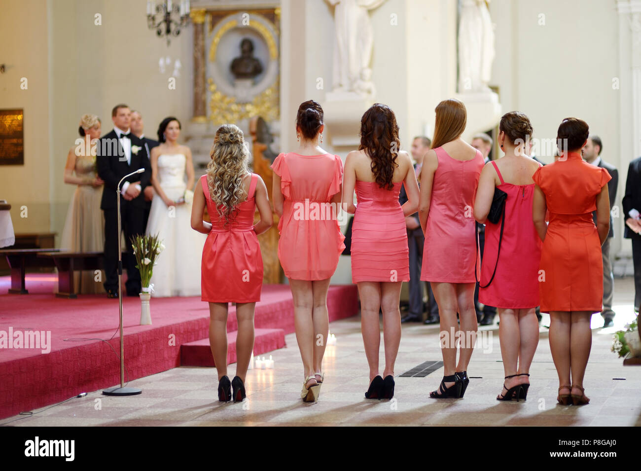 Fila de damas de honor vestidos de coral en la boda Fotografía stock - Alamy