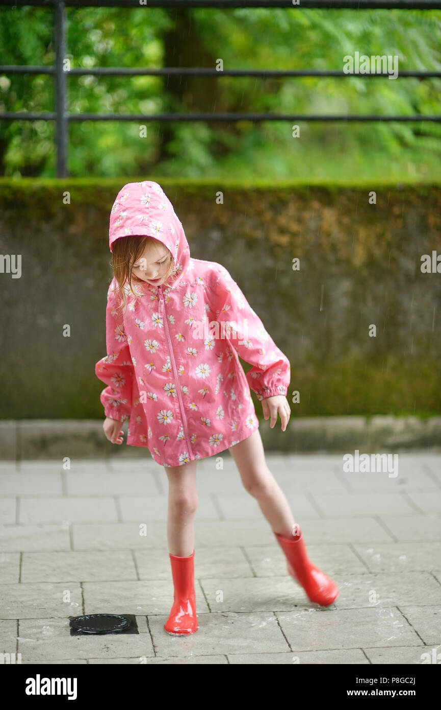 Adorable niña en botas de agua de pie en un caniche Fotografía de stock -  Alamy