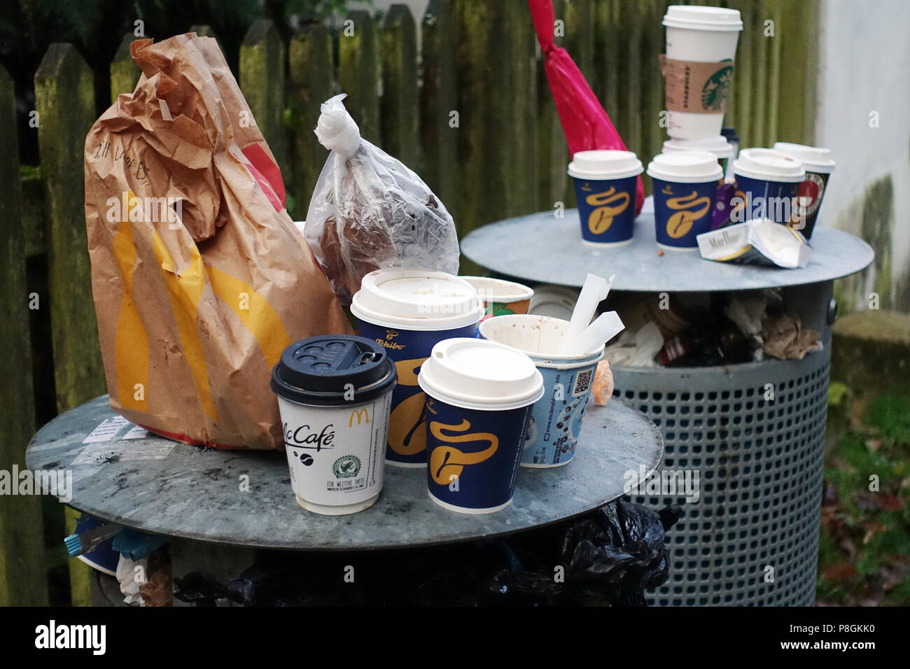 Berlín, Alemania, tazas de café y bolsas vacías en cubos de basura saturada. Foto de stock
