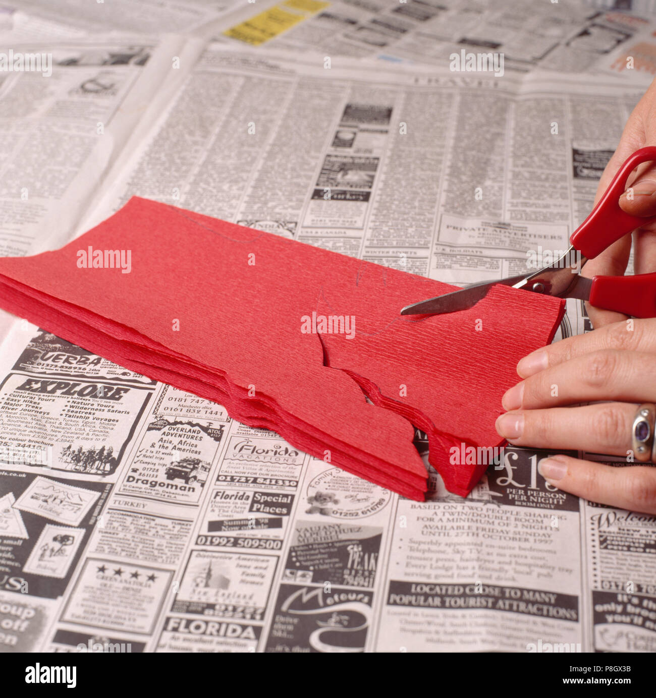 Close-up de Manos usando tijeras para cortar el patrón de plegado de papel  crepé rojo SÓLO PARA USO EDITORIAL Fotografía de stock - Alamy