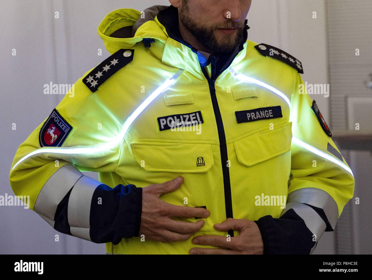 Abultar grua experimental Hannover, Alemania. 12 de julio de 2018. Un oficial de policía, mostrando  la nueva chaqueta con luz stripesof la Policía de Baja Sajonia. Los  chalecos antibalas deben ser gastados en la parte