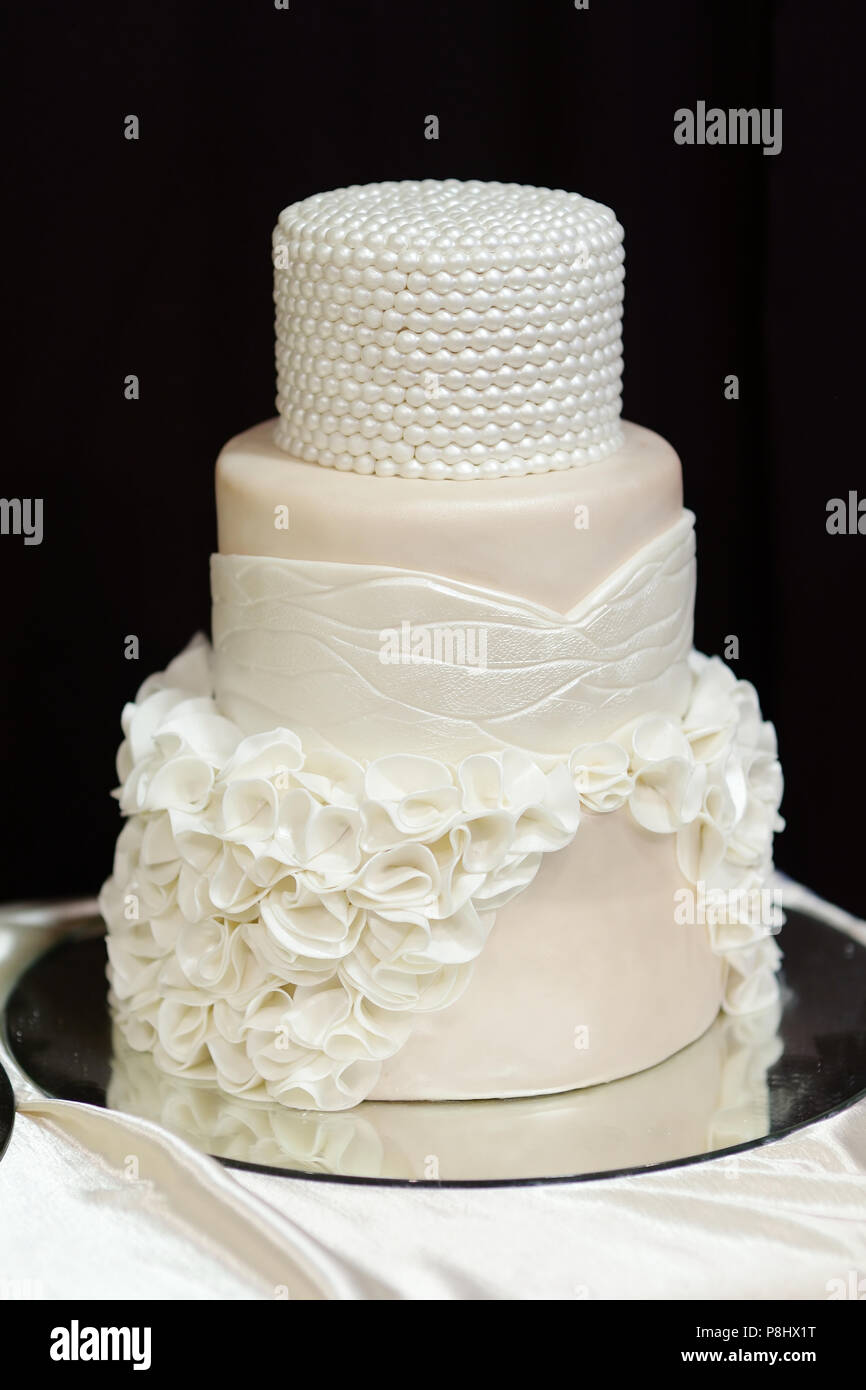 Pastel de boda blanco decorado con perlas blancas y flores Fotografía de  stock - Alamy