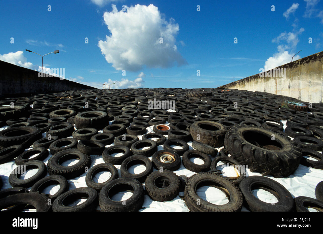 Neumáticos de coches usados sobre una lámina de silo. Foto de stock