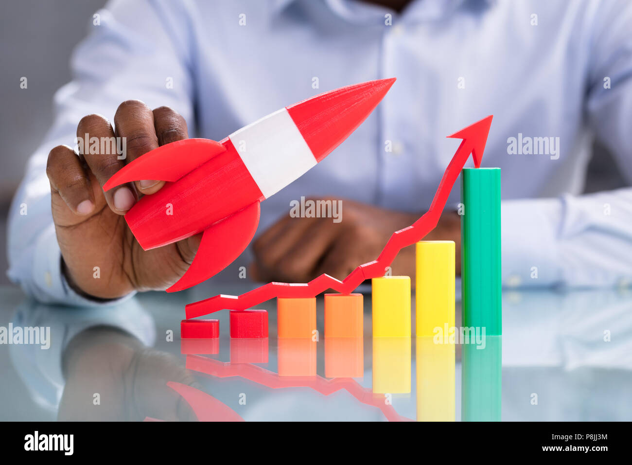 Aumentar gráfico con Rocket delante del empresario calcular la factura en el lugar de trabajo Foto de stock