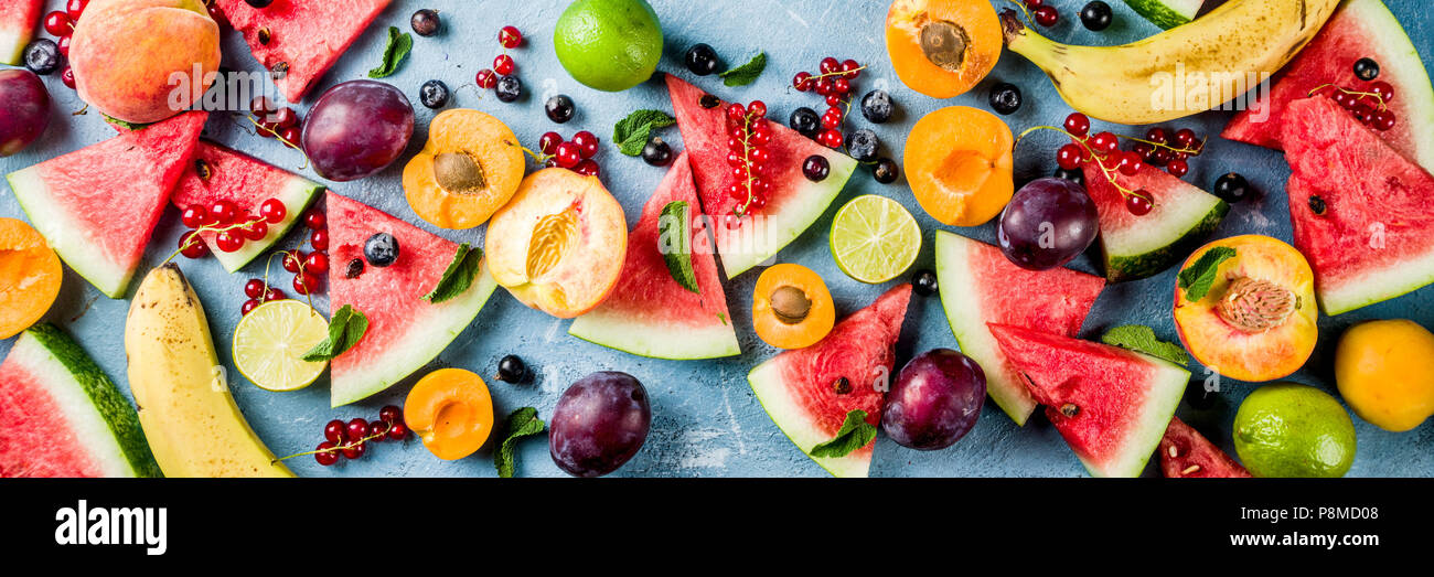Vitamina concepto de comida de verano, diversas frutas y bayas sandía melocotón menta Albaricoque Ciruela grosella blueberry, plano creativo yacía sobre una luz azul backgrou Foto de stock
