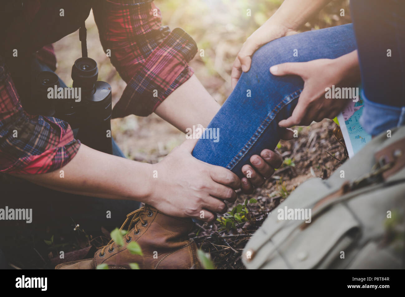 Pareja joven asiática para viajeros de senderismo lesión de tobillo sobre un fondo verde, concepto de senderismo. Foto de stock