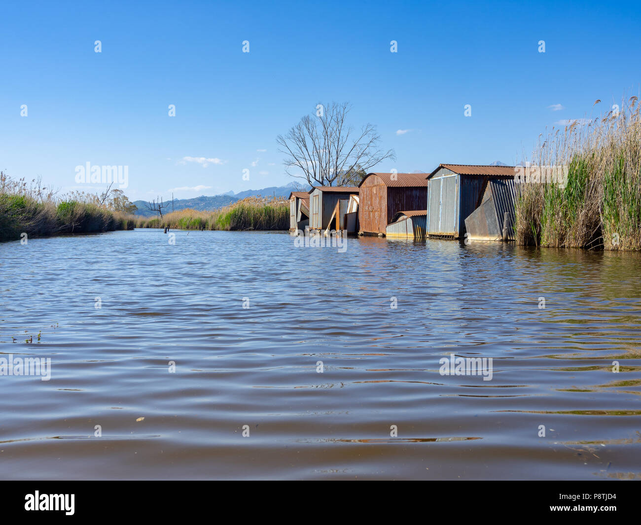 Abandonadas chozas de hierro a lo largo de la orilla del lago Foto de stock