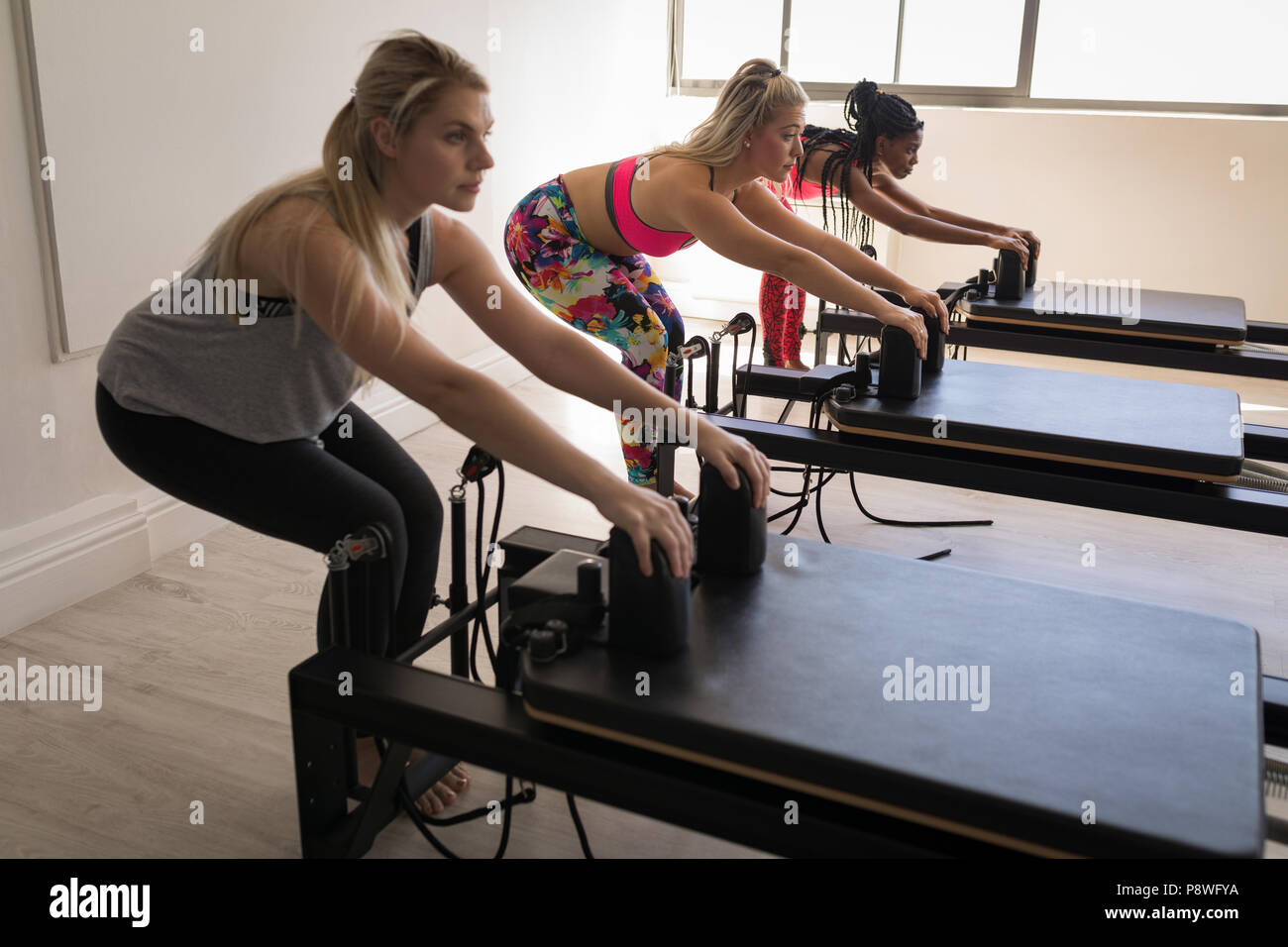 máquina de pilates, mujer de raza mixta joven en ropa deportiva que hace  ejercicio en el gimnasio Fotografía de stock - Alamy